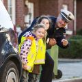 Ein Polizeibeamter übt mit Kindern das sichere Verhalten im Straßenverkehr