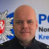 Michael Bich vor Leinwand mit Logo der Kreispolizeibehörde Düren 