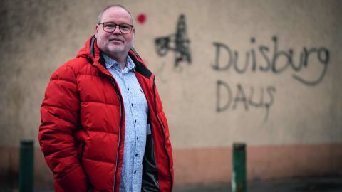 Jörg Lange, Leiter der Stabsstelle Sozialleistungsbetrug bei der Stadt Duisburg vor Hauswand mit Graffiti in Duisburg